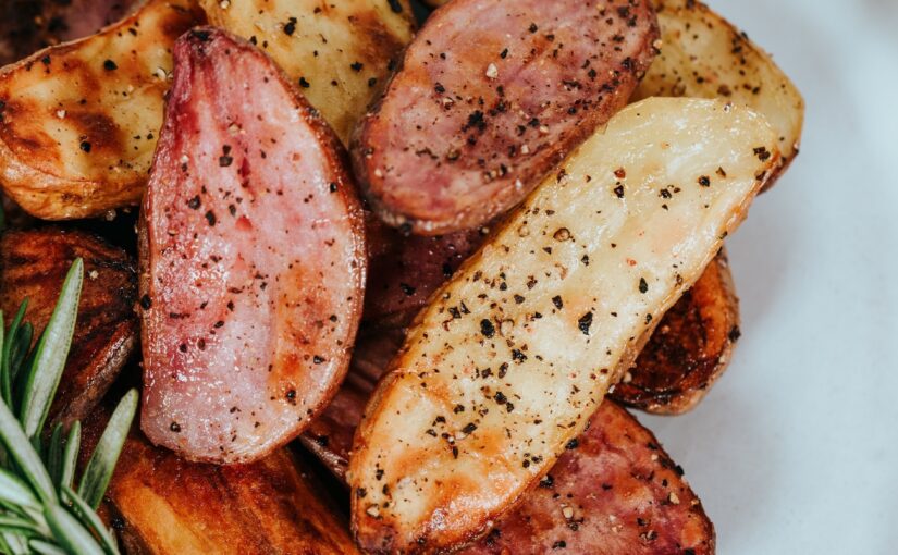 Seasoned potato wedges piled high on a white plate