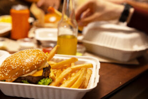 Crispy fries and a cheeseburger in a cardboard carton