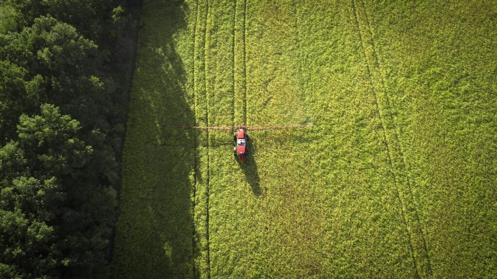 An overhead view of a piece of farm equipment in a vast green field