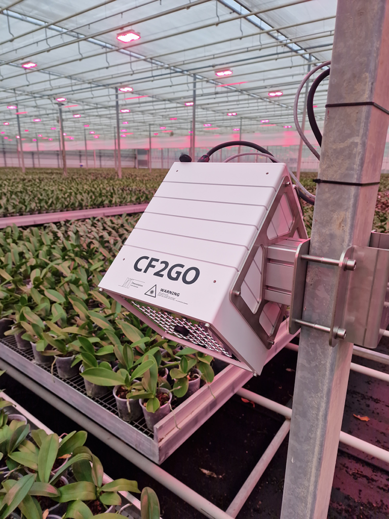 A monitoring device is mounted on a greenhouse pole