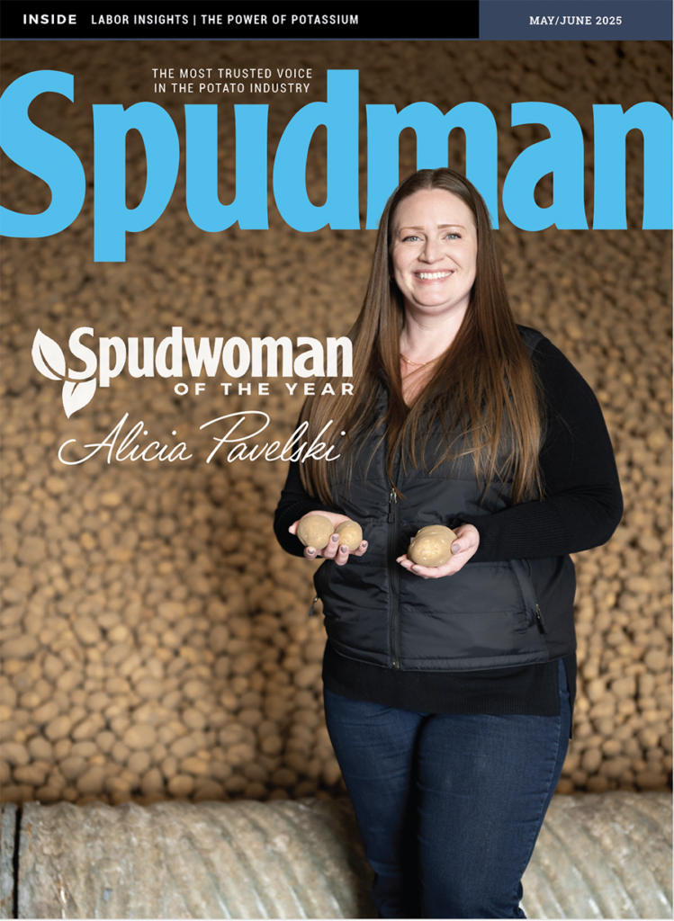 Spudwoman of the Alicia Pavelski holds potatoes in her hands in front of a banked of stored tubers