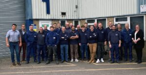 A group of employees pose in front of a building