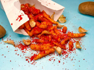 Firecracker fries, seasoned with smoked paprika, cayenne and garlic powder, spill out of a paper bag