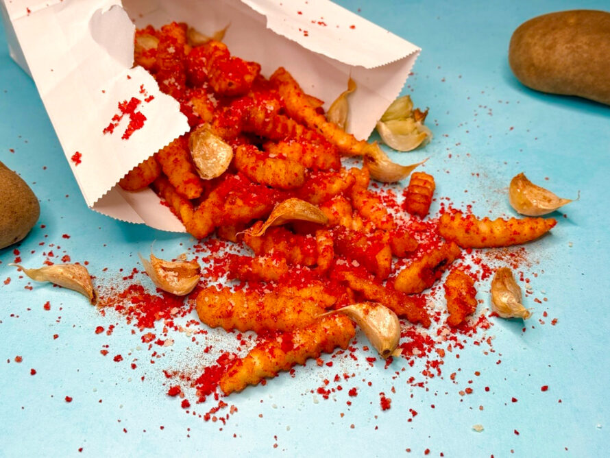 Firecracker fries, seasoned with smoked paprika, cayenne and garlic powder, spill out of a paper bag