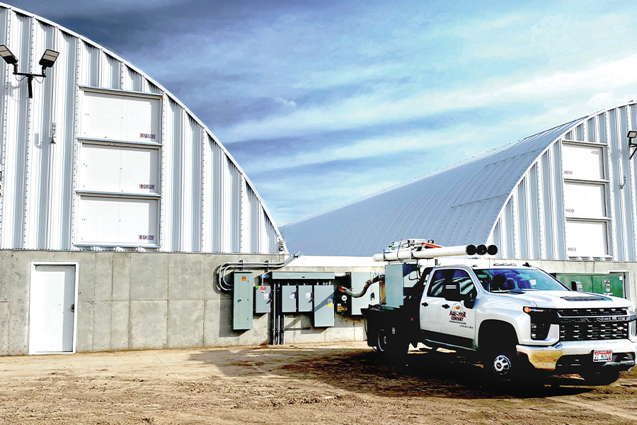 A large white potato storage building under a blue sky