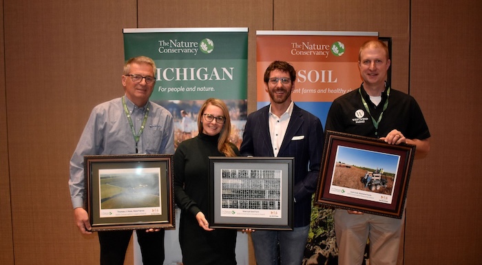 Four people posing with awards