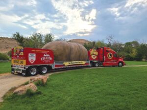 The big red Idaho potato truck under a sun-streaked sky