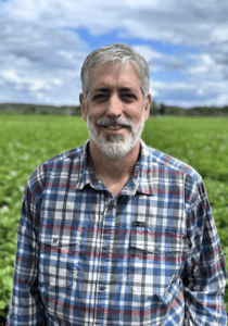 Headshot of man standing in a potato field