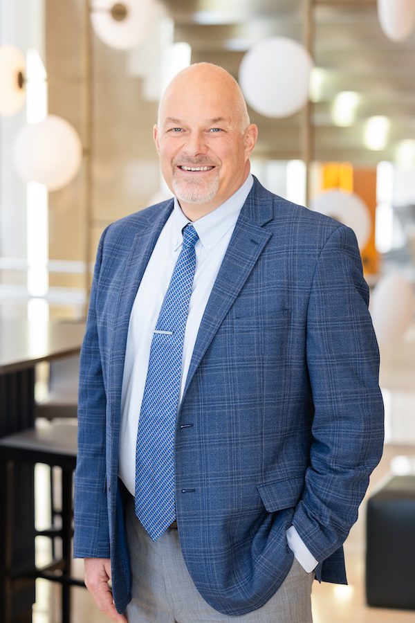 Man in blue tie, white shirt and dark blue suit jacket